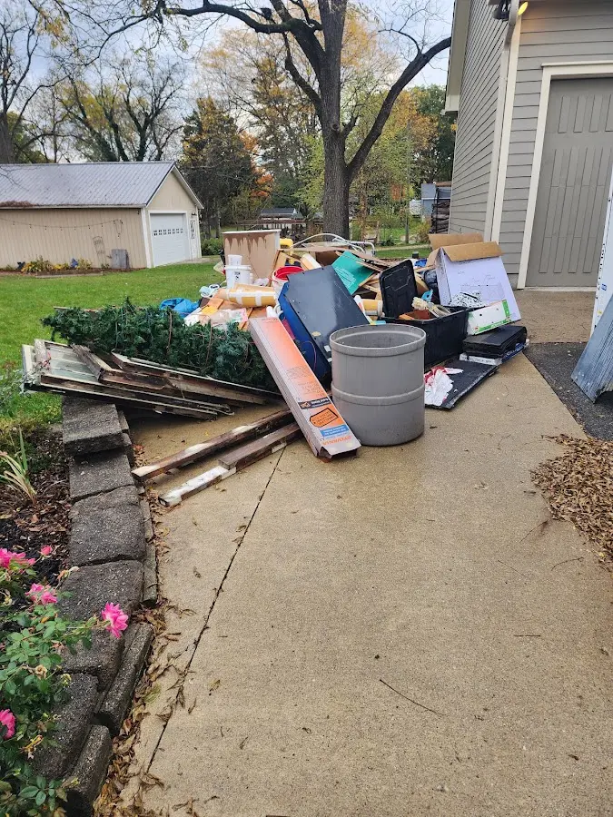 Dumpster being loaded with debris for 12 Yard Dumpster Rental in Iron Mountain